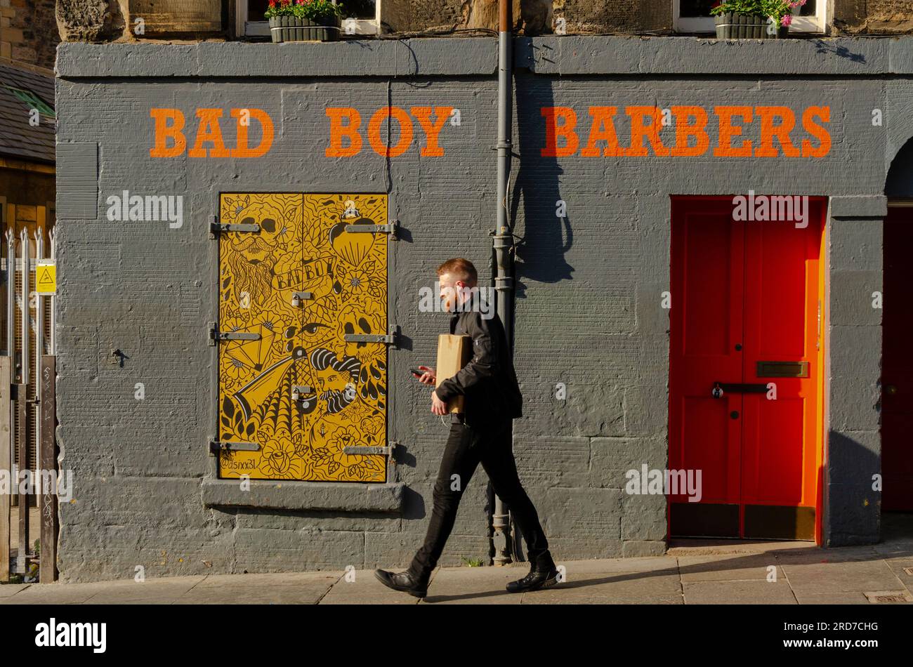 EDINBURGH, SCHOTTLAND, Großbritannien - 09. Juni 2023 - Ein Mann geht vorbei an "Bad Boy Barbers" in der Altstadt von Edinburgh, Schottland, Großbritannien - Foto: Geopix Stockfoto