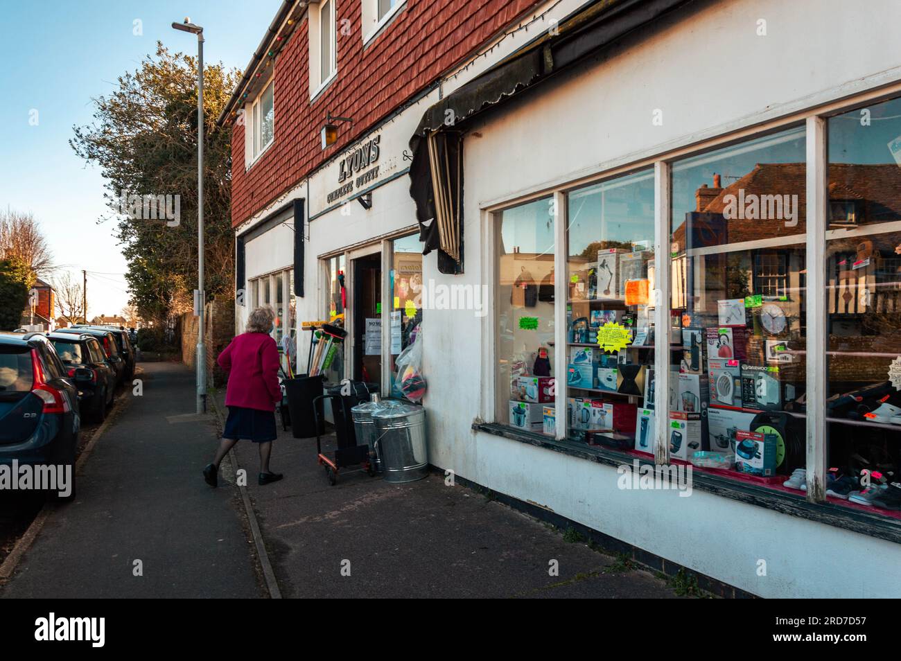 Eine Frau, die in einen alten Laden geht, Lydd, Kent, England Stockfoto