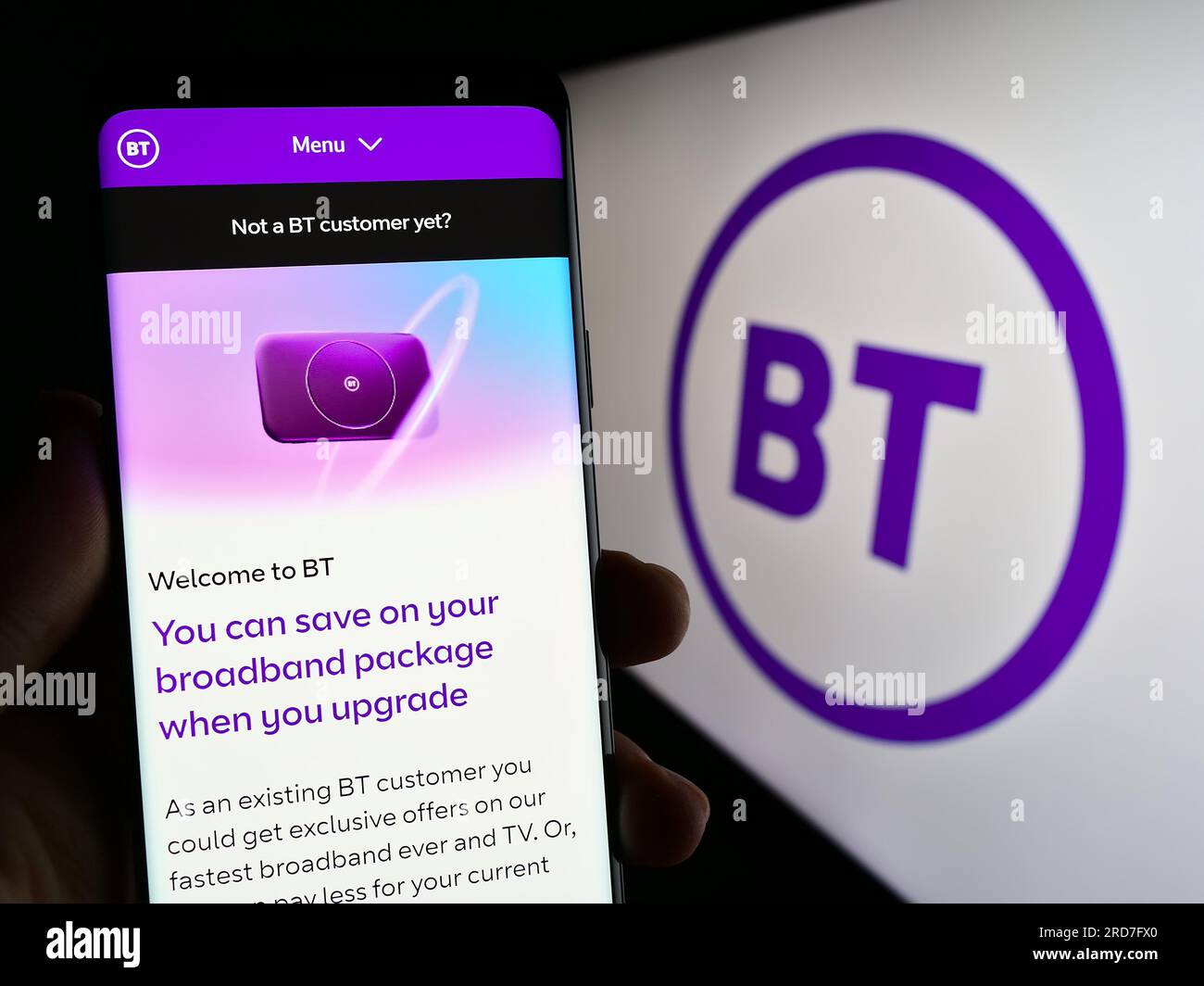 Person, die ein Mobiltelefon mit einer Webseite des britischen Telekommunikationsunternehmens BT Group plc auf dem Bildschirm mit Logo hält. Konzentrieren Sie sich auf die Mitte des Telefondisplays. Stockfoto