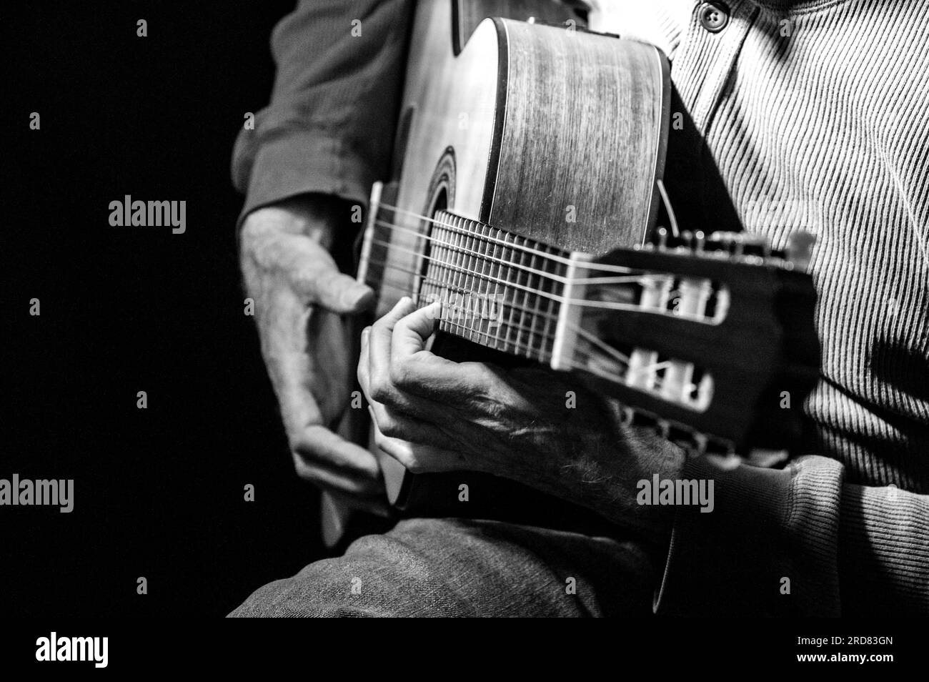 Dezentes Schwarzweißfoto eines Mannes, der Gitarre spielt Stockfoto