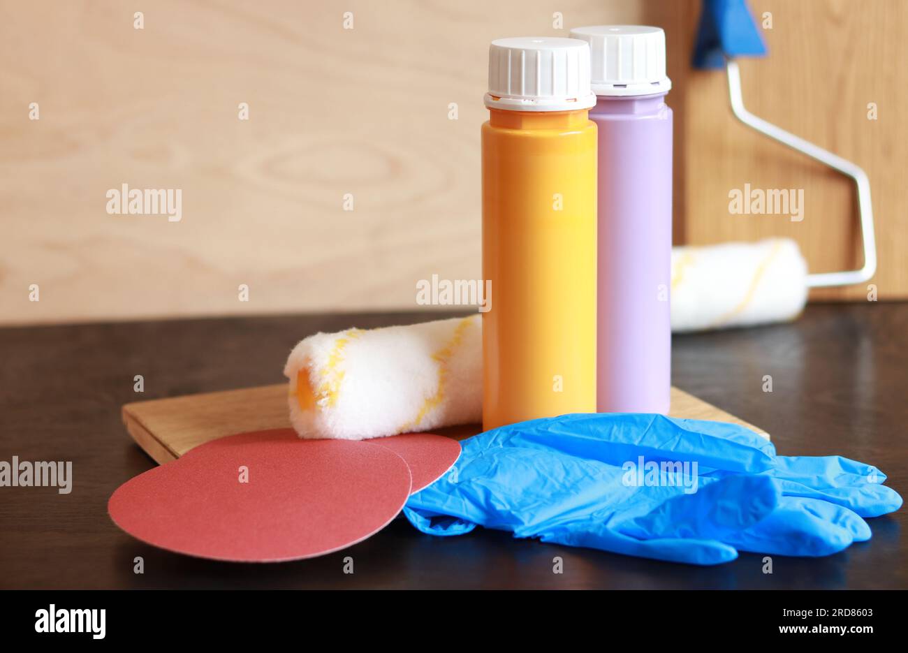 Zwei Flaschen Acrylfarbe auf einem Holztisch. Für die Reparatur benötigte Teile. Reparaturfarben, Gummihandschuhe, Schleifpapier und Holzbohlen. Platz für Text Stockfoto