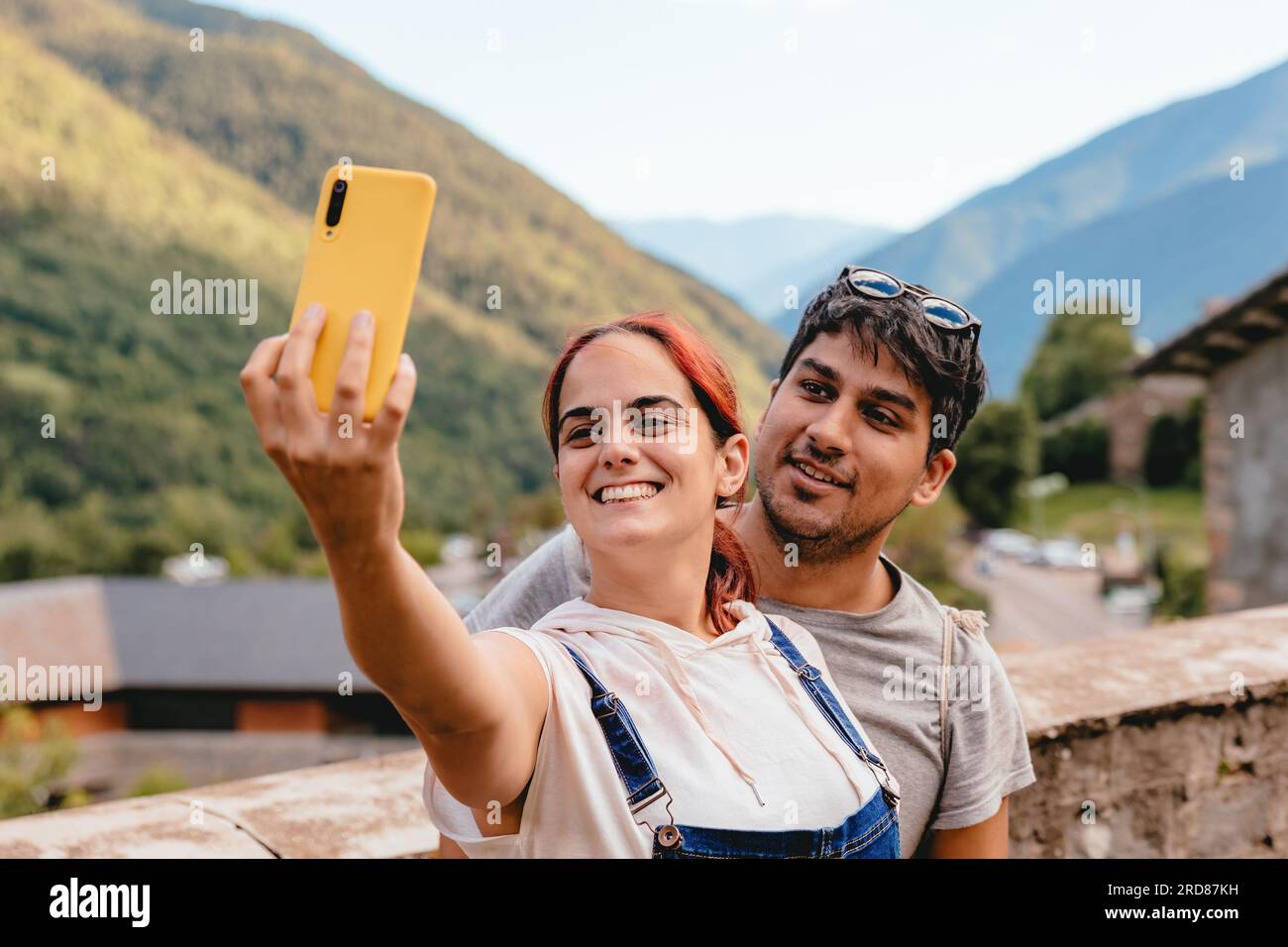 Ein Paar, das ein Selfie mit dem Telefon macht, während er in einem Bergdorf auf dem Land unterwegs ist. Urlaub und Sommerurlaub im Freien in Huesca, Spanien Stockfoto