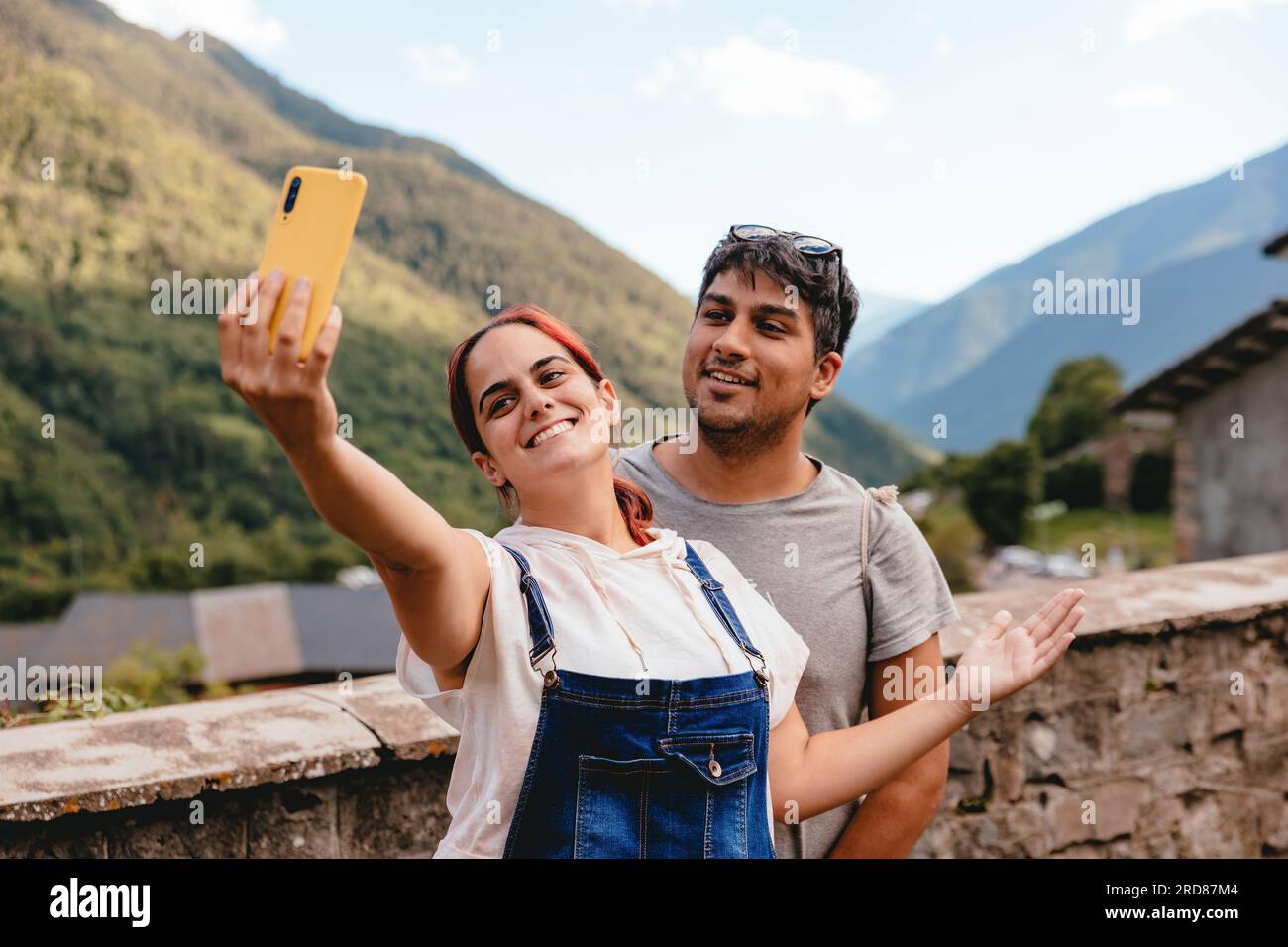 Ein junges Paar, das ein Selfie mit dem Handy macht, während es in einem Bergdorf auf dem Land unterwegs ist. Urlaubsreise und Sommerurlaub im Freien in Huesca, Sp Stockfoto