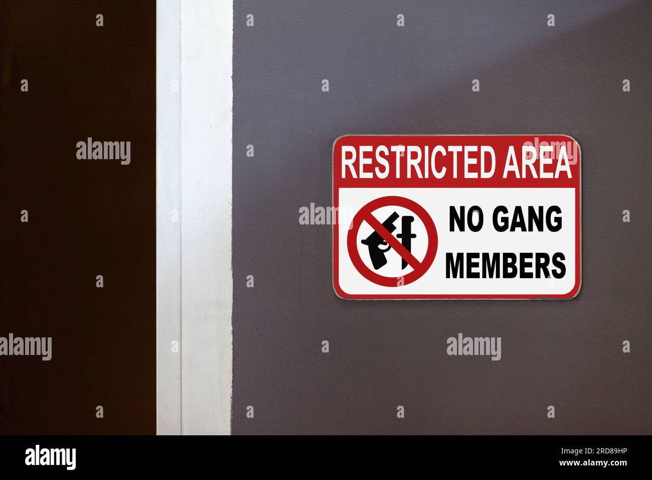 Rot-weißes Schild mit der Aufschrift „Restricted Area, No Gang members“ an der Seite einer offenen Tür. Stockfoto