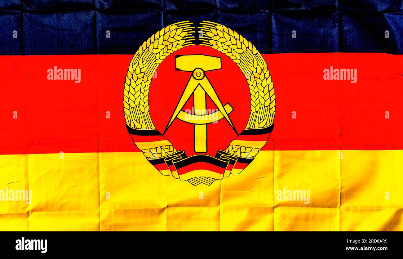 Old National Emblem Red Black Yellow Flag East Germany Checkpoint Charlie Berlin Deutschland. Hammer Workers' Symbol Compass Intelligensa Symbol und Rye R Stockfoto