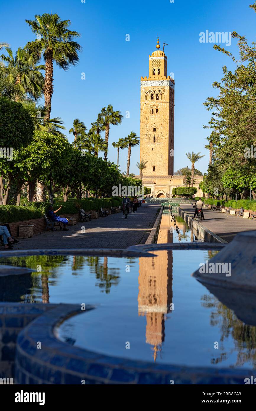 Antiker Minarettturm der Koutoubia-Moschee, UNESCO-Weltkulturerbe, reflektiert in einem Brunnen in den formellen Gärten, Marrakesch, Marokko Stockfoto