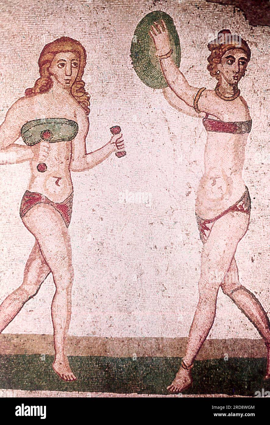 Dieses Foto eines Mosaiks von zwei Mädchen, das dem heutigen Bikini ähnelt, wurde im Sommer 1970 auf der Piazza Armerina in Sizilien aufgenommen. Dieses Foto eines Mosaiks eines Mädchens im heutigen Bikini wurde im Sommer 1970 auf der Piazza Armerina in Sizilien aufgenommen. Die Piazza Armerina beherbergt die römische Villa del Casale und ihre berühmten Mosaiken, die „besten Mosaike in situ in der römischen Welt“, wie von der UNESCO beschrieben, die sie 1997 in ihre Liste des Weltkulturerbes aufgenommen hat. Die Villa Romana war eine üppige Patrizier-Residenz, die im Zentrum eines riesigen Latifundiums (Landwirtschaftsgelände) am Ende des Jahres erbaut wurde Stockfoto