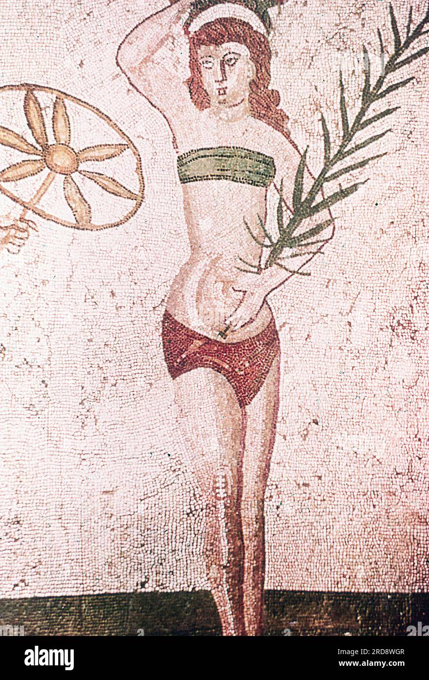 Dieses Foto eines Mosaci eines Mädchens im heutigen Bikini wurde im Sommer 1970 auf der Piazza Armerina in Sizilien aufgenommen. Dieses Foto eines Mosaiks eines Mädchens im heutigen Bikini wurde im Sommer 1970 auf der Piazza Armerina in Sizilien aufgenommen. Die Piazza Armerina beherbergt die römische Villa del Casale und ihre berühmten Mosaiken, die „besten Mosaike in situ in der römischen Welt“, wie von der UNESCO beschrieben, die sie 1997 in ihre Liste des Weltkulturerbes aufgenommen hat. Villa Romana war eine üppige Patrizier-Residenz, erbaut im Zentrum eines riesigen Latifundiums (Landwirtschaftsgelände) am Ende des Stockfoto