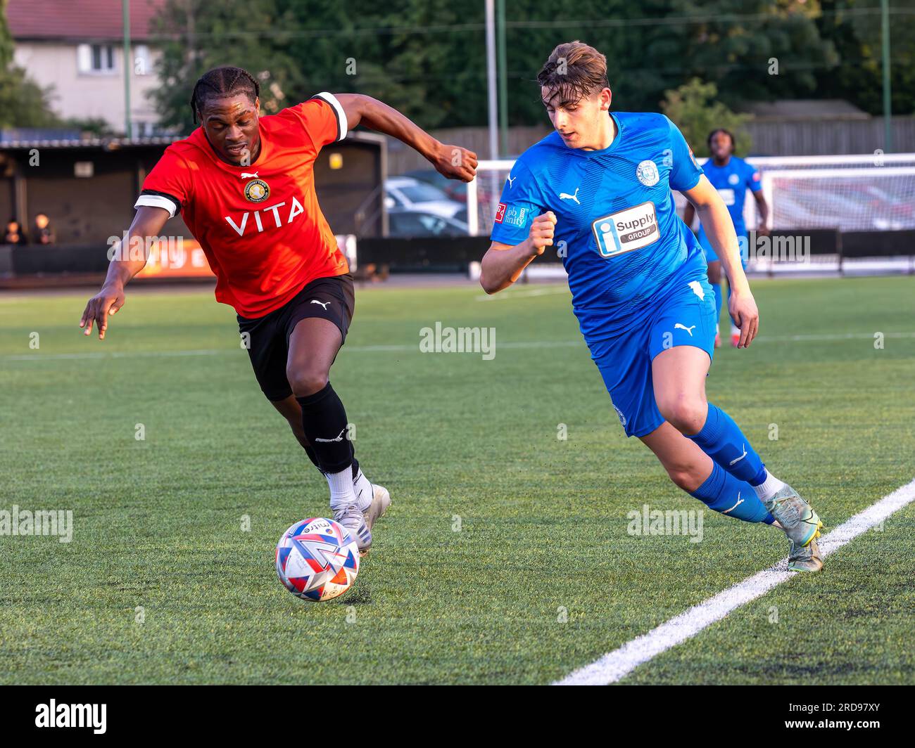 Ein Spieler von Warrington Rylands läuft den linken Flügel entlang und wird von einem Verteidiger von Stockport Town im Stockport Sports Village auf einem 3G-m-Platz verfolgt Stockfoto