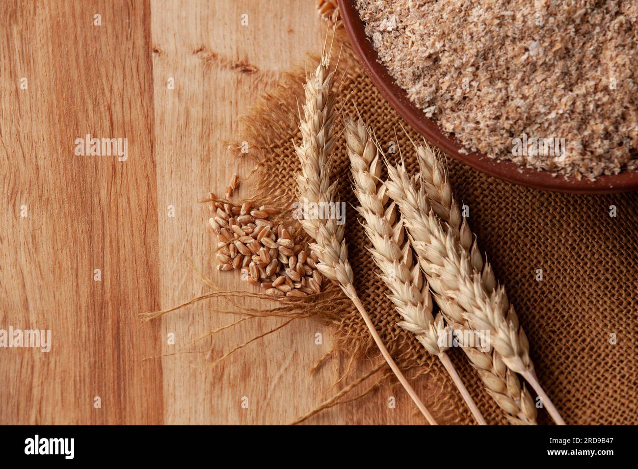Weizenohren auf einer Schüssel Kleie. Lebensmittelkonzept mit Kopierraum. Stockfoto