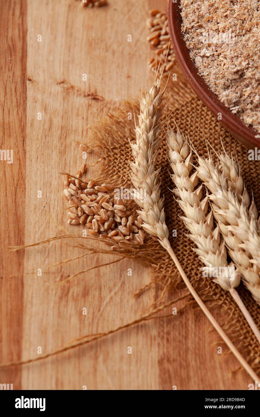 Weizenohren auf einer Schüssel Kleie. Lebensmittelkonzept mit Kopierraum. Stockfoto