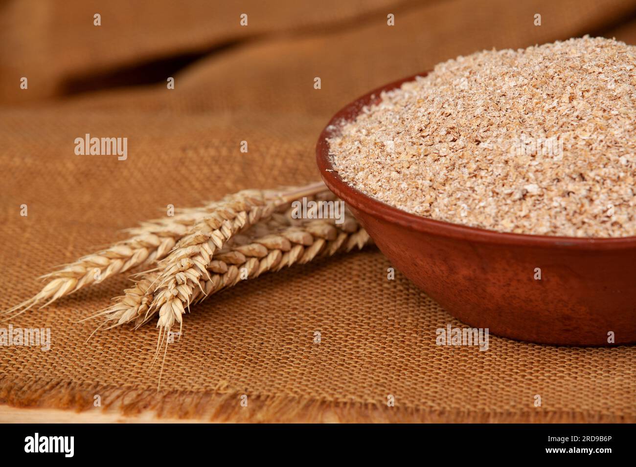 Weizenohren auf einer Schüssel Kleie. Lebensmittelkonzept mit Kopierraum. Stockfoto