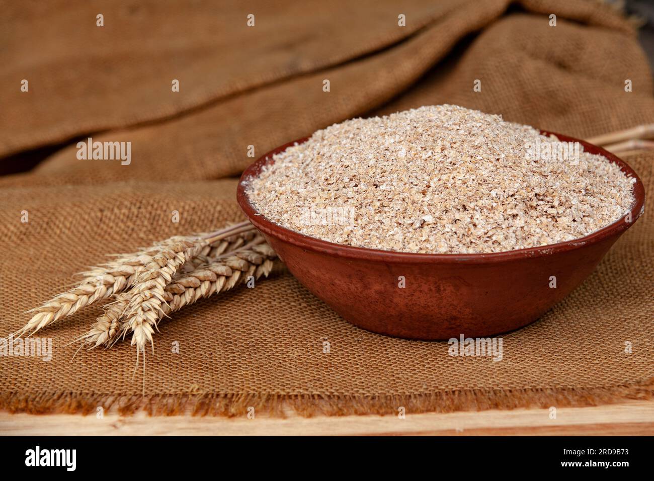 Weizenohren auf einer Schüssel Kleie. Lebensmittelkonzept mit Kopierraum. Stockfoto