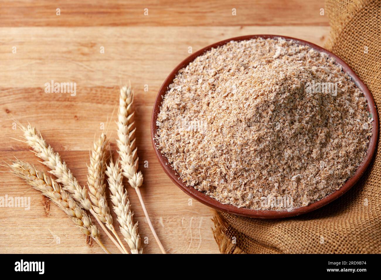 Weizenohren auf einer Schüssel Kleie. Lebensmittelkonzept mit Kopierraum. Stockfoto