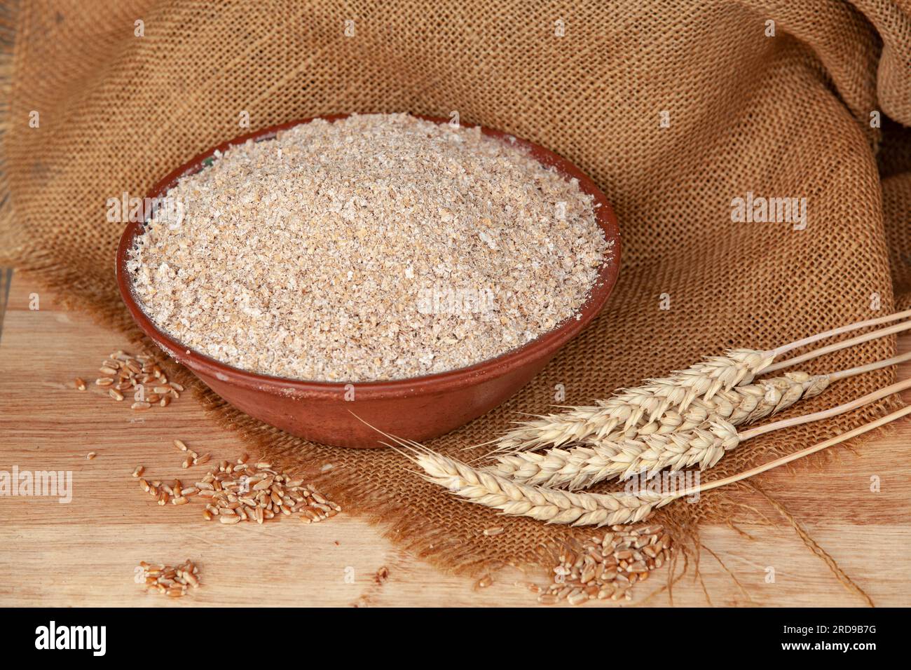 Weizenohren auf einer Schüssel Kleie. Lebensmittelkonzept mit Kopierraum. Stockfoto