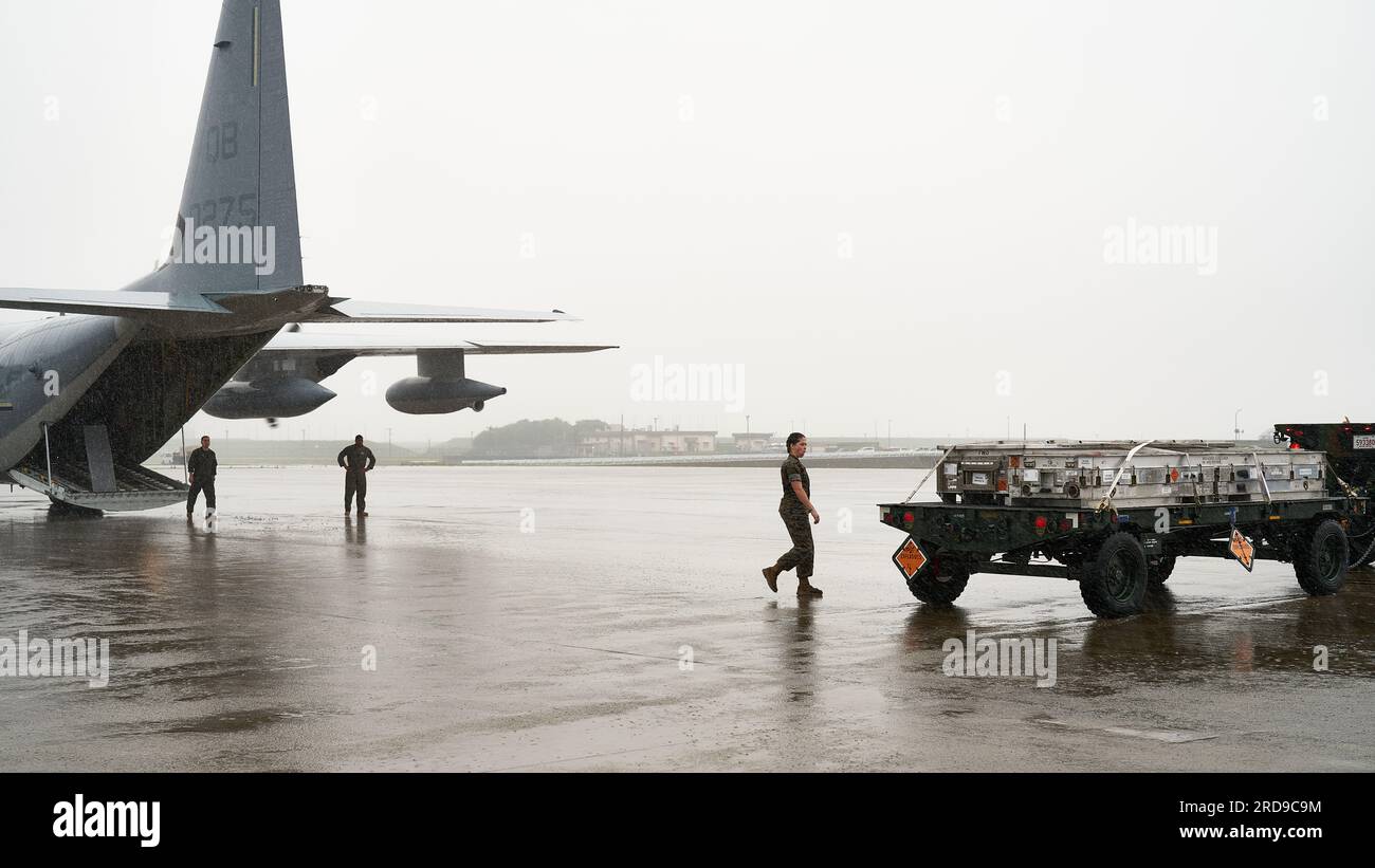 USA Marines, die der Marine Aviation Logistics Squadron 12, Marine Aircraft Group 12 und Marine Aerial Tanker Transport Squadron 352 (VMGR-352) zugeteilt sind, bewegen am 7. Juli 2023 in der Marine Corps Air Station Iwakuni, Japan, Kampfmittel auf ein KC-130J Super Hercules-Flugzeug. VMGR-352 und MALS-12 haben ihre Fähigkeit unter Beweis gestellt, Kampfmittel bei MCAS Iwakuni, das einzigartig qualifiziert ist, um die gemeinsame Truppe zu ermöglichen, durch die Nutzung des gemeinsam gelegenen Hafens und Flugplatzes der Station, der als Zwischenstopp für den Betrieb nichtökologischer/nichtbiologischer Luftfahrzeuge dient, oder einer Reihe anderer betrieblicher Tätigkeiten zu beladen. (USA Marinekorps Stockfoto