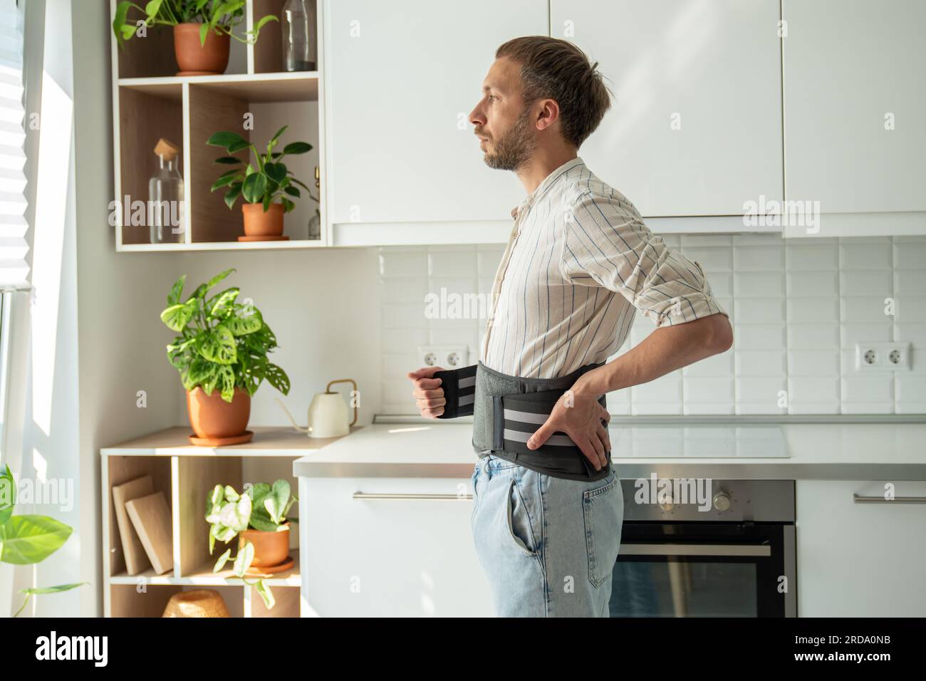 Mann mit Rückenstützkorsett am unteren Rücken zur Behandlung der Hernie, Entlastung der Wirbelsäule. Stockfoto