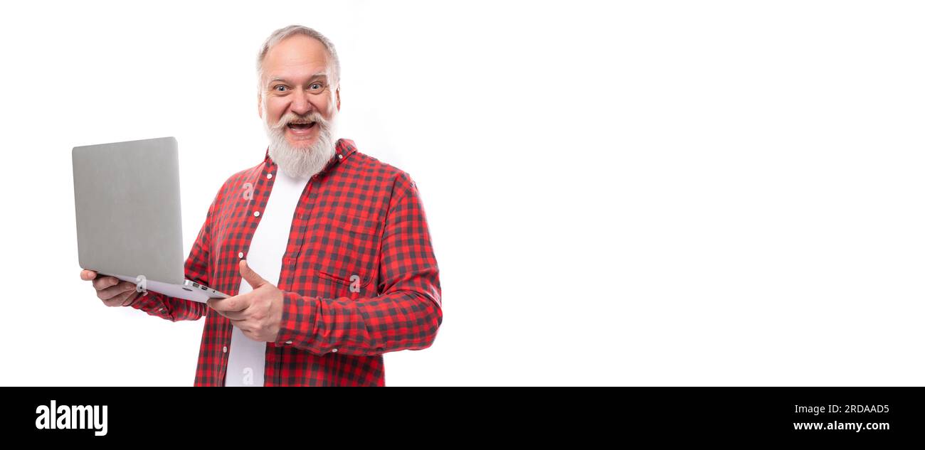 Ein intelligenter 60s-Mann mittleren Alters in einem stilvollen Hemd beherrscht ein Notebook Stockfoto