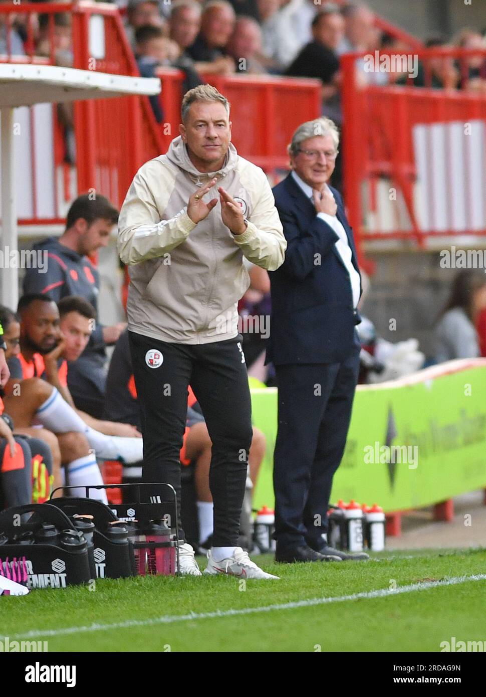 Crawley Manager Scott Lindsey mit Crystal Palace Manager Roy Hodgson hinter ihm während des Vorsaison Freundschaftsspiels zwischen Crawley Town und Crystal Palace im Broadfield Stadium, Crawley, Großbritannien - 19. Juli 2023 Stockfoto