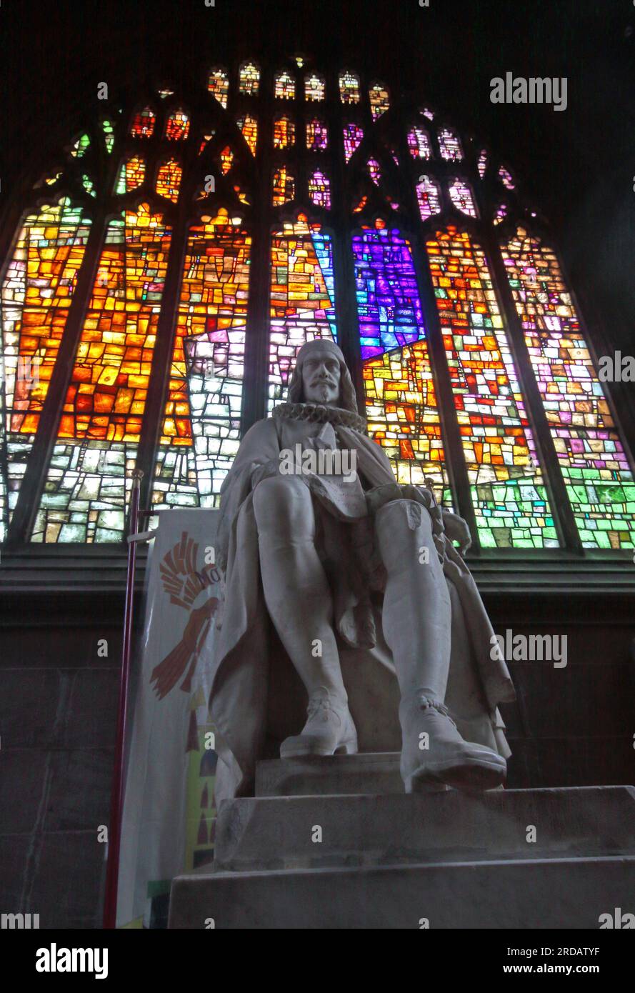 Viktorianische Statue Humphrey Chetham in der Kathedrale von Manchester, erfolgreicher Händler, vor einem Buntglasfenster, Victoria St, Manchester, UK, M3 1SX Stockfoto