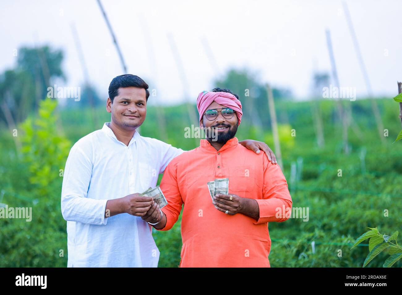 Indischer Bauer, der seinem Arbeiter Geld gibt, intelligenter Bauer, junger Bauer, intelligente Landwirtschaft Stockfoto