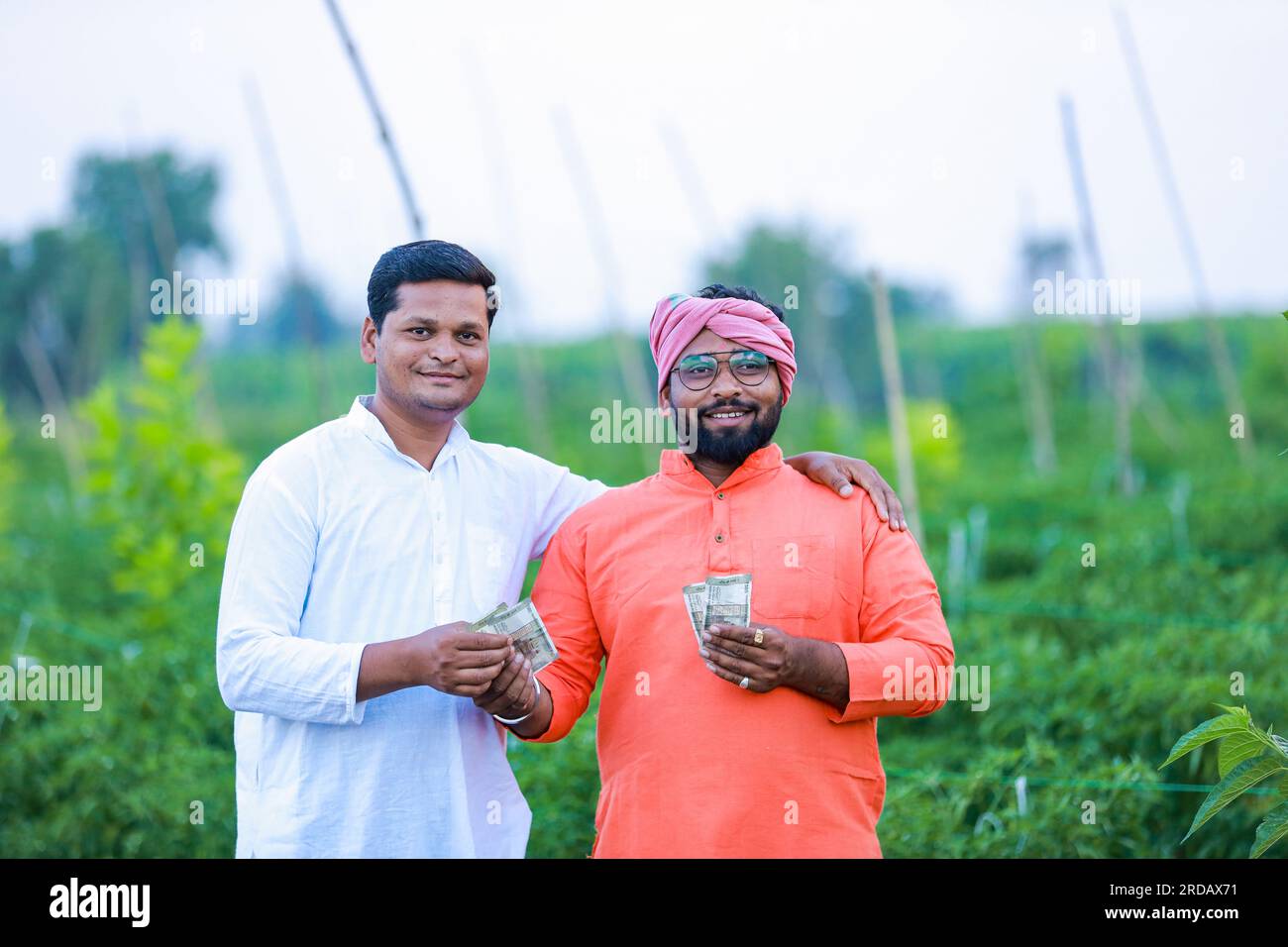 Indischer Bauer, der seinem Arbeiter Geld gibt, intelligenter Bauer, junger Bauer, intelligente Landwirtschaft Stockfoto