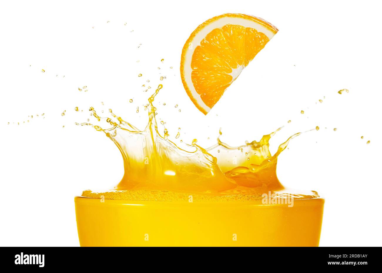 Orangenscheibe, die in spritzernden, frisch gepressten Saft fällt, isoliert auf weißem Hintergrund. Ein echtes Studiofoto. Stockfoto