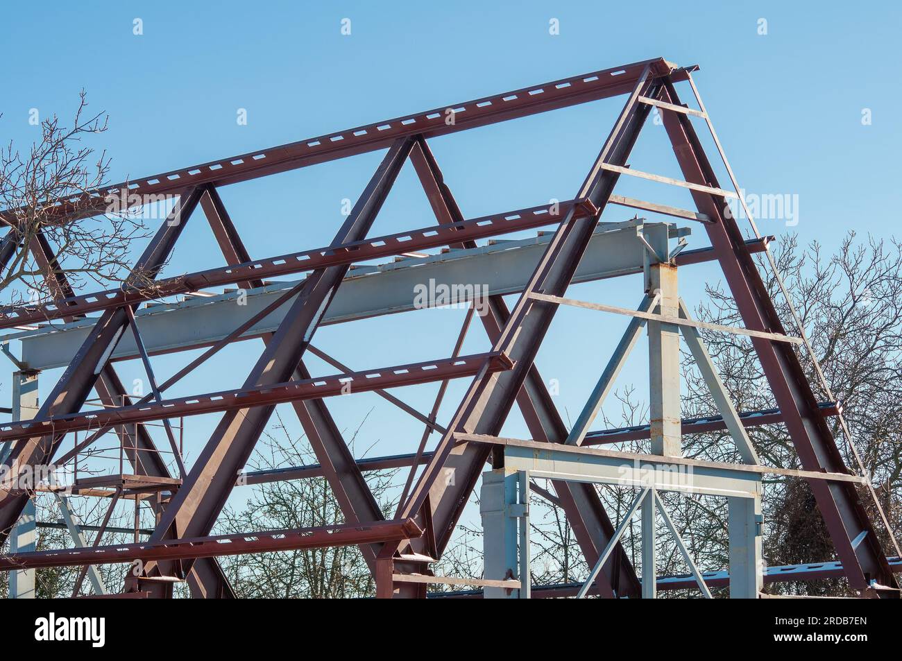 Bau eines Hangars aus Metallkonstruktionen. Rahmen aus Stahl-I-Trägern. Das Skelett des Gebäudes Stockfoto