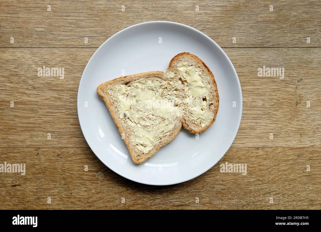 Scheibe Butterbrot auf weißem Teller Stockfoto