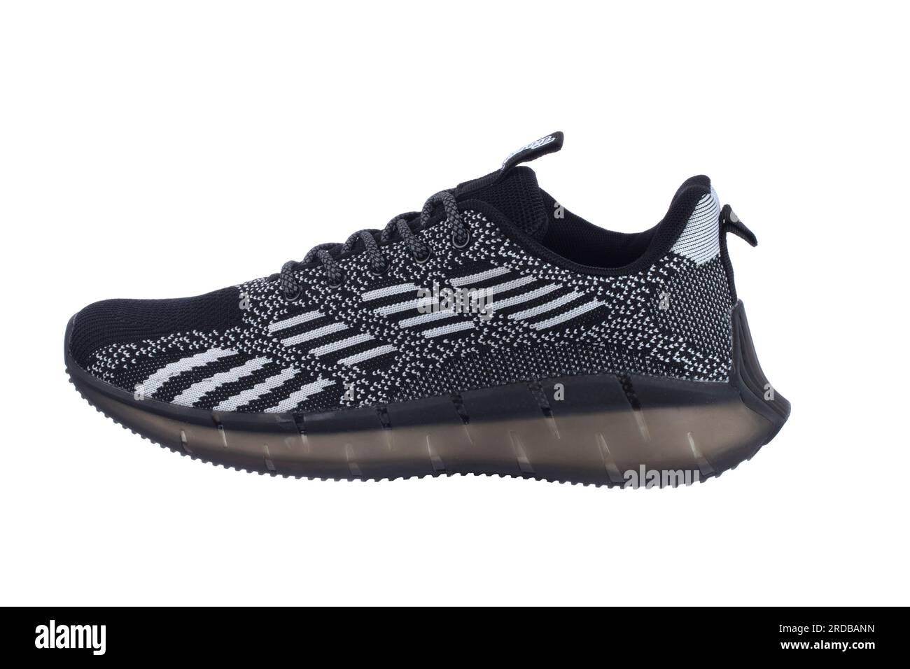 Schwarzer Sneaker mit grauen Streifen auf weißem Hintergrund. Stockfoto
