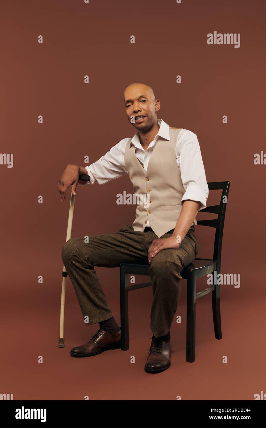 Inklusion, echte Menschen, afroamerikanischer Mann mit Myasthenia-gravis-Syndrom, sitzt auf dem Stuhl und schaut in die Kamera, dunkelhäutiger Mann mit chronischer Dis Stockfoto