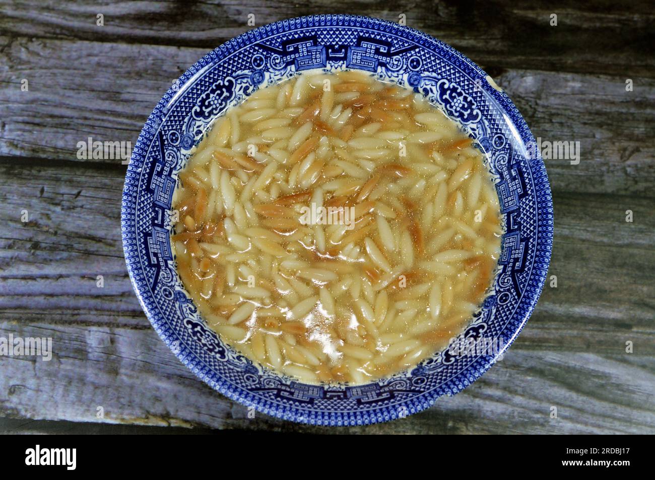 Nahöstliche ägyptische Pasta-Suppe, auch bekannt als Shorbet Lesan El Asfour, traditionelle ägyptische Komfortgerichte aus Orzo Pasta, Butter und Oliven Stockfoto