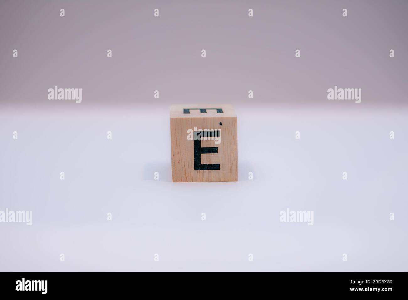 Holzblock mit der Aufschrift „E“ auf weißem Hintergrund. Stockfoto