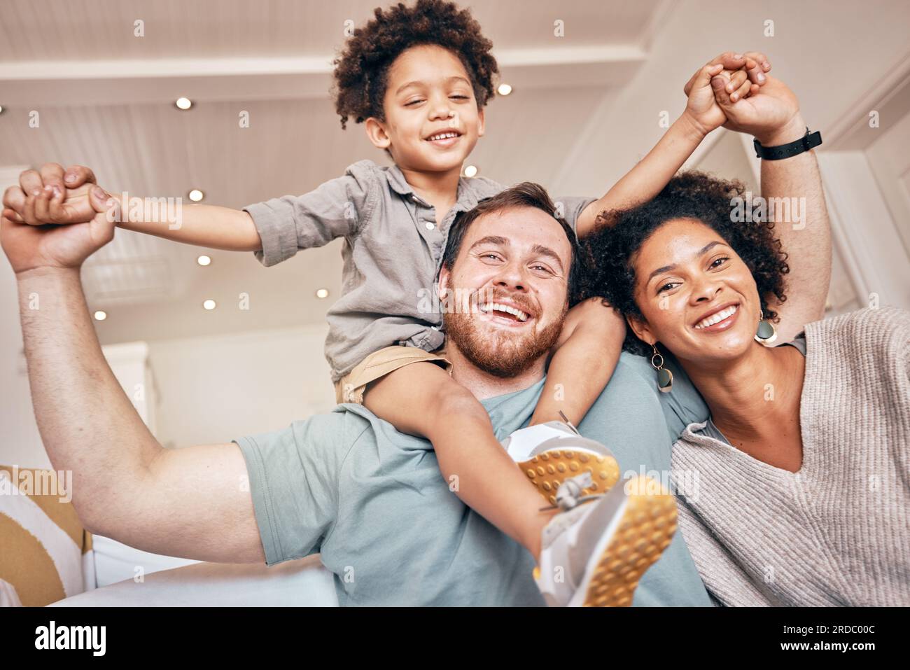 Mutter, Vater und Junge auf den Schultern, Huckepack und Porträt zu Hause mit Lächeln, Händchen halten und Solidarität. Familienhaus, Mutter und Vater Stockfoto