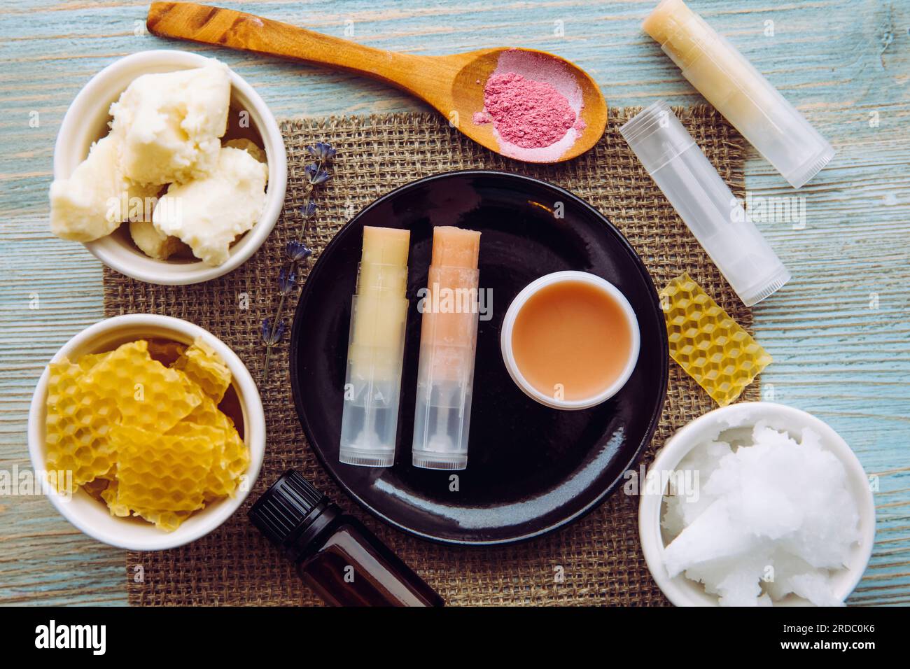 Zutaten für hausgemachten Lippenbalsam: sheabutter, ätherisches Öl, mineralisches Farbpulver, Bienenwachs, Kokosnussöl. Hausgemachte Lippenbalsam-Lippenstift-Mischung. Stockfoto