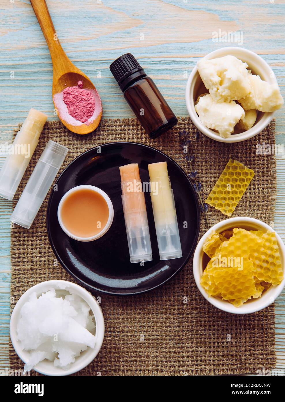 Zutaten für hausgemachten Lippenbalsam: sheabutter, ätherisches Öl, mineralisches Farbpulver, Bienenwachs, Kokosnussöl. Hausgemachte Lippenbalsam-Lippenstift-Mischung. Stockfoto