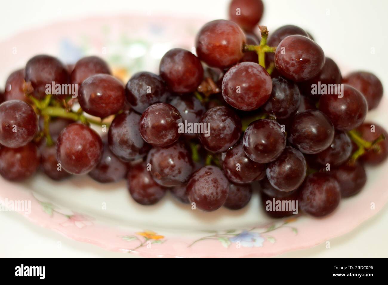 Rote Weintrauben, eine Frucht, botanisch eine Beere der Laubholzreben der blühenden Pflanzengattung Vitis. Trauben sind nicht klimakterische Obstsorten; Stockfoto