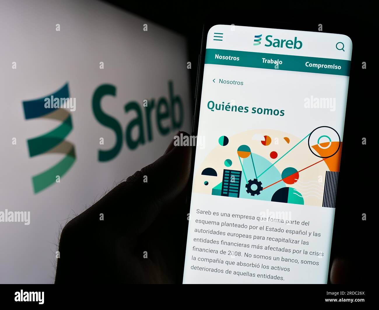 Person, die ein Handy mit der Webseite der spanischen Bad Bank Sareb auf dem Bildschirm vor dem Firmenlogo hält. Konzentrieren Sie sich auf die Mitte des Telefondisplays. Stockfoto