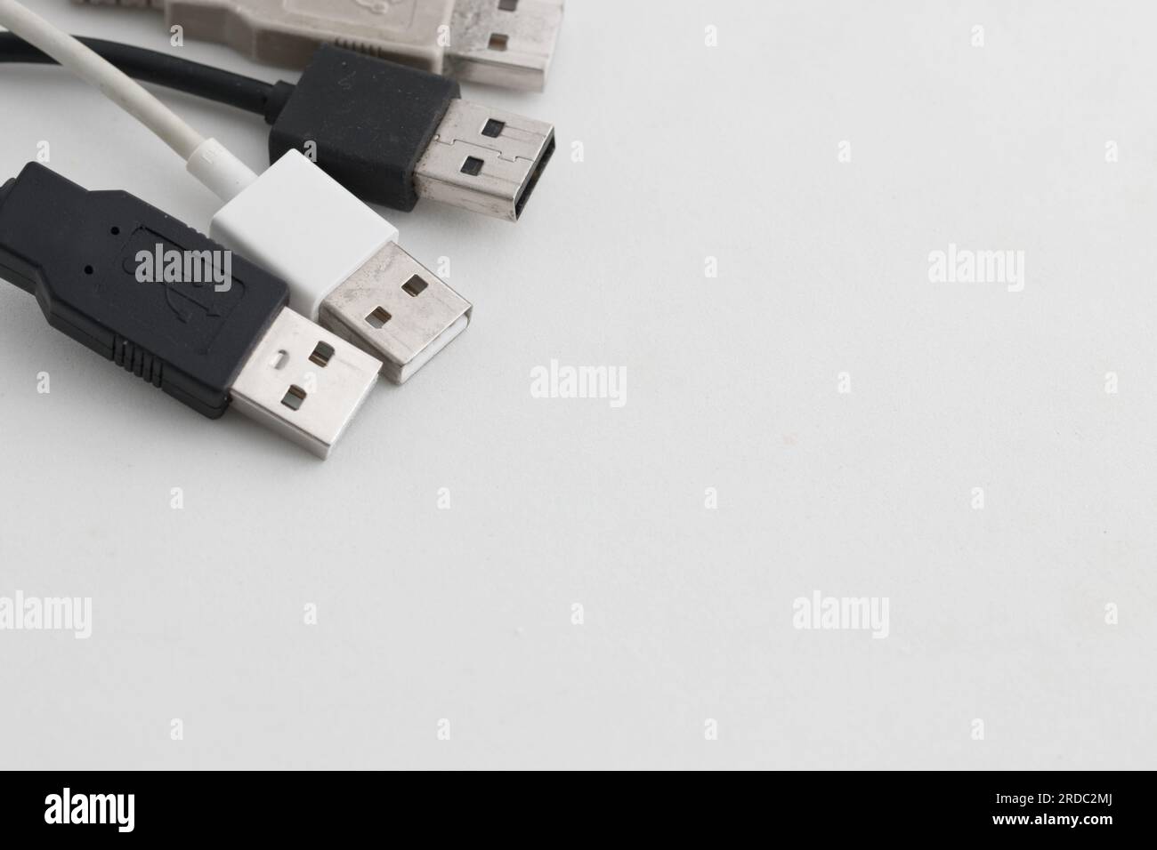 Einige mehrfarbige Kabel mit USB-Anschlüssen auf weißem Hintergrund mit Kopierbereich auf der rechten Seite Stockfoto