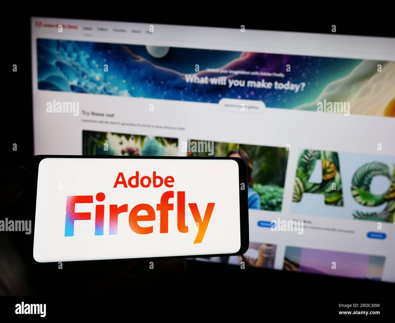 Person, die ein Mobiltelefon mit dem Logo des generativen KI-Produkts Adobe Firefly auf dem Bildschirm vor der Unternehmenswebseite hält. Konzentrieren Sie sich auf das Display des Telefons. Stockfoto