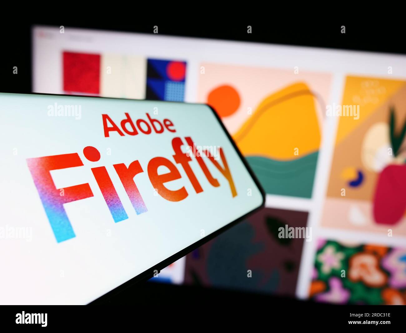Smartphone mit Logo des generativen KI-Produkts Adobe Firefly auf dem Bildschirm vor der Business-Website. Fokus auf die Mitte links des Telefondisplays. Stockfoto