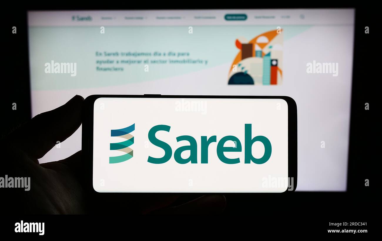 Person mit Smartphone und Logo der spanischen Bad Bank Sareb auf dem Bildschirm vor der Website. Konzentrieren Sie sich auf das Display des Telefons. Stockfoto