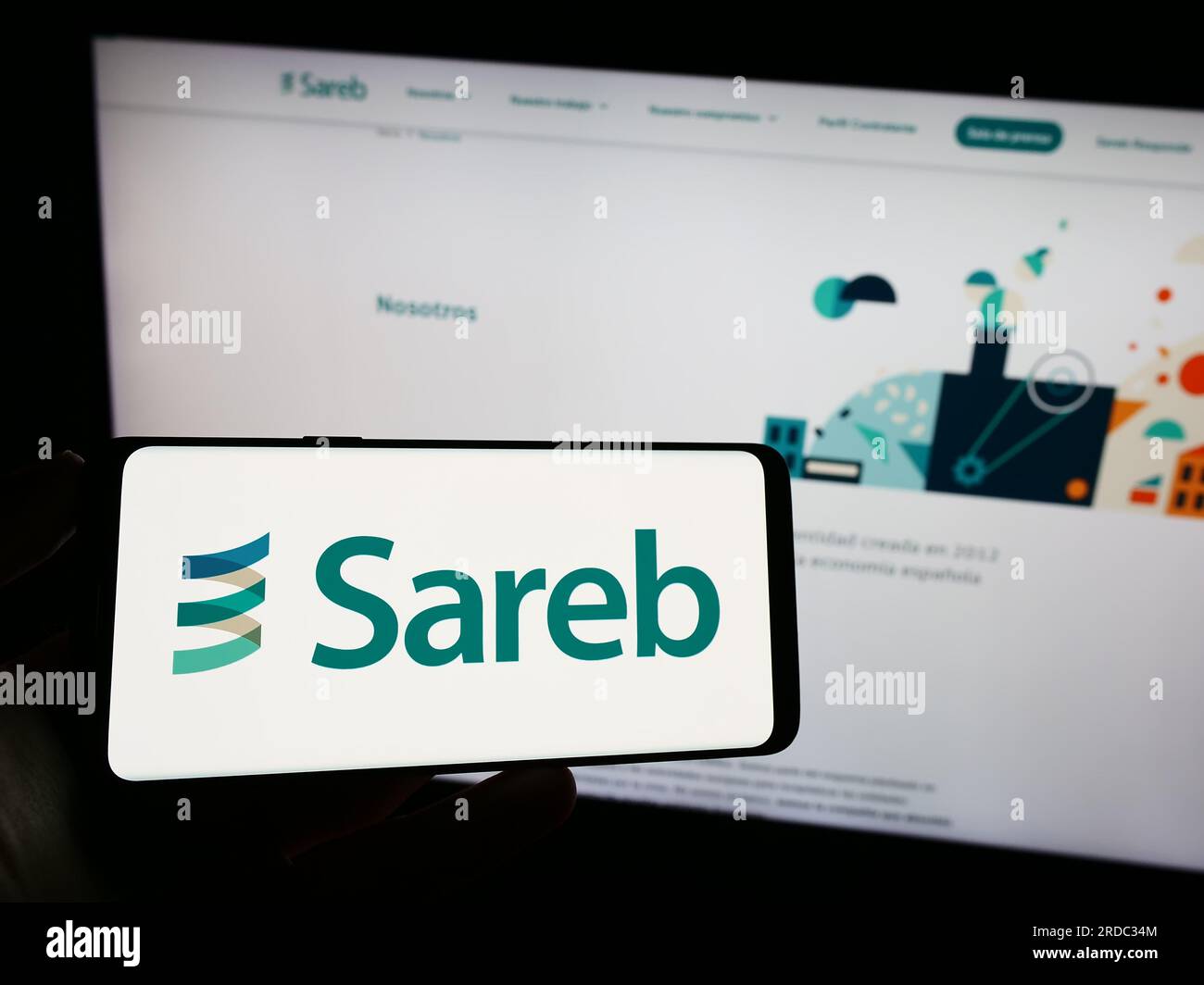 Person, die ein Mobiltelefon mit dem Logo der spanischen Bad Bank Sareb auf dem Bildschirm vor der Business-Webseite hält. Konzentrieren Sie sich auf das Display des Telefons. Stockfoto