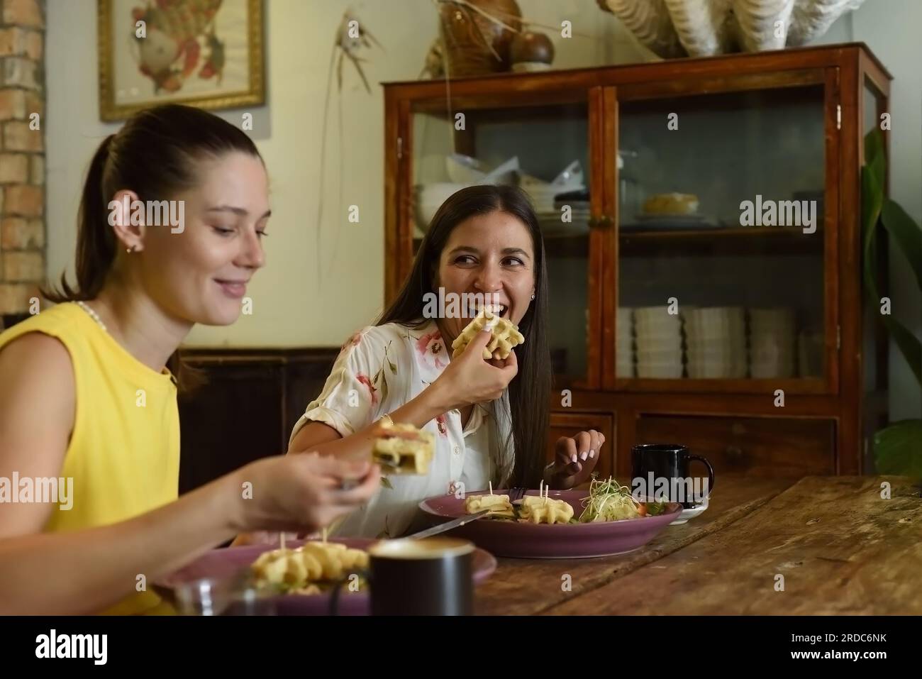 Zwei beste Freunde, die sich unterhalten und in einem Café essen Stockfoto