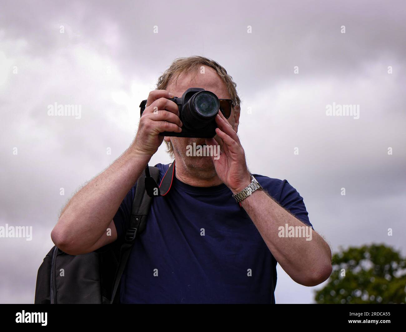 Porträt eines Mannes, der mit einer Kamera steht Stockfoto