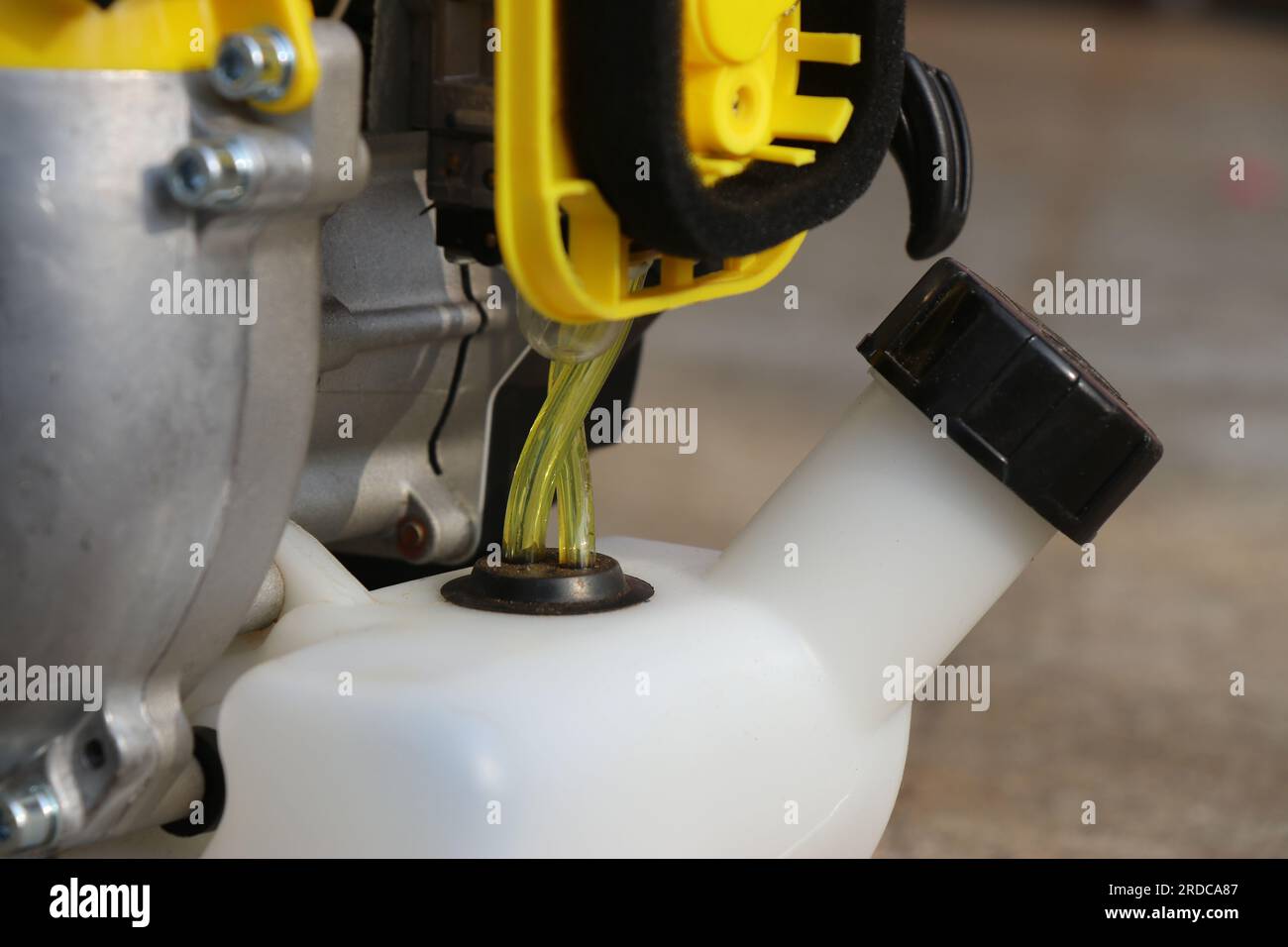 Nahaufnahme des Benzinpumpenschlauchs für die Kraftstoffzufuhr in einem Bürstenschneider. Teile eines benzinbetriebenen Buschtrimmers mit Blick auf Vergaser und Gastank Stockfoto