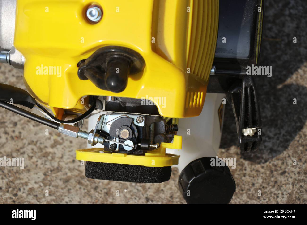 Kraftstofftank und Vergaser einer benzinbetriebenen Motorsense-Maschine. Teile für benzinbetriebene Trimmer Stockfoto