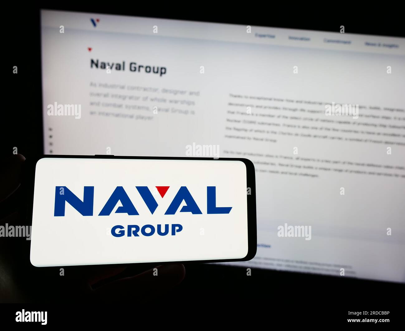 Person, die ein Smartphone mit dem Logo des französischen Verteidigungsunternehmens Naval Group S.A. auf dem Bildschirm vor der Website hält. Konzentrieren Sie sich auf das Display des Telefons. Stockfoto