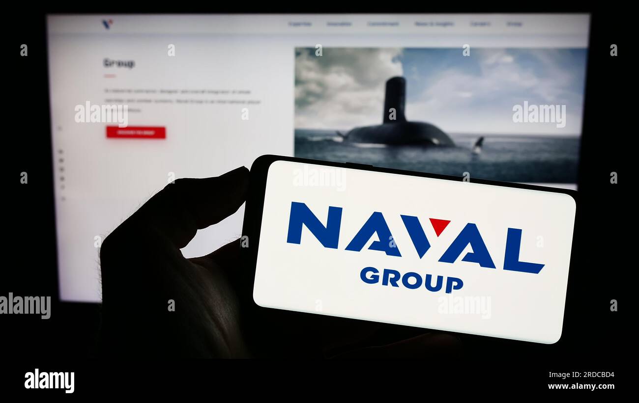 Person, die ein Mobiltelefon mit dem Logo des französischen Verteidigungsunternehmens Naval Group SA auf dem Bildschirm vor der Unternehmenswebseite hält. Konzentrieren Sie sich auf das Display des Telefons. Stockfoto