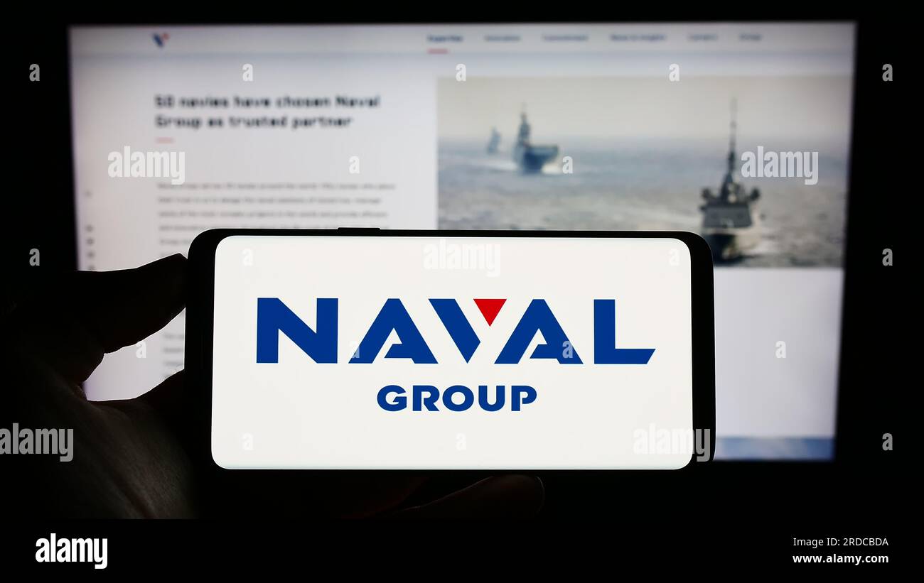 Person, die ein Handy mit dem Logo der französischen Verteidigungsfirma Naval Group S.A. auf dem Bildschirm vor der geschäftlichen Webseite hält. Konzentrieren Sie sich auf das Display des Telefons. Stockfoto